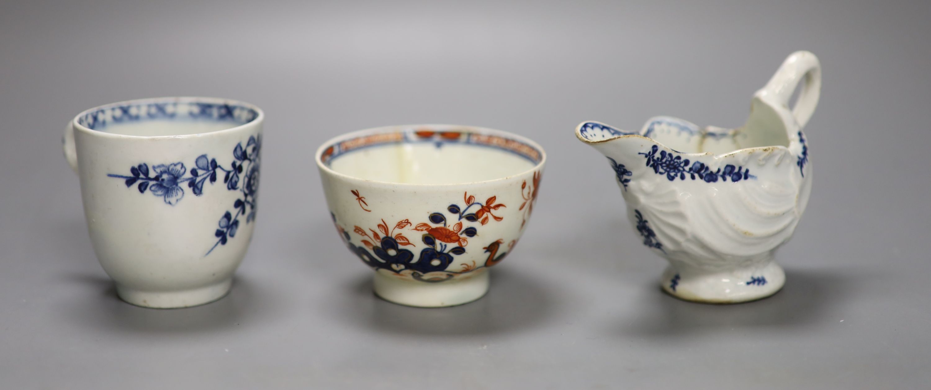 A Lowestoft shell moulded ewer painted with floral sprigs, a Lowestoft coffee cup,